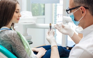 a dentist in Rockwall explaining how dental implants work 