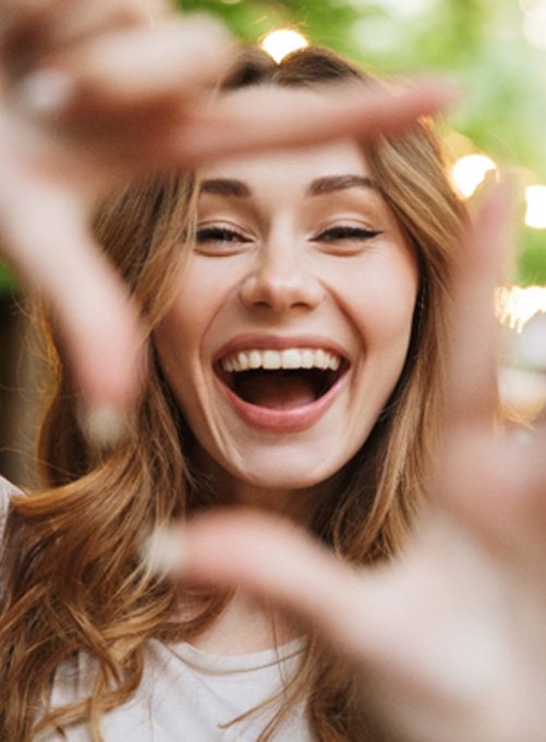 a woman smiling after visiting her dentist in Rockwall