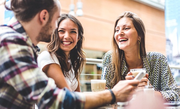 Group of friends smiling at lunch outside