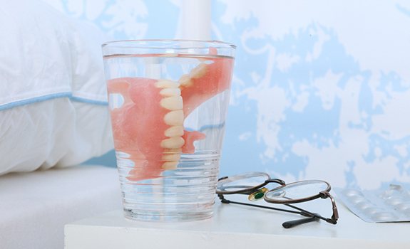 Dentures in Rockwall in water glass on bedside table