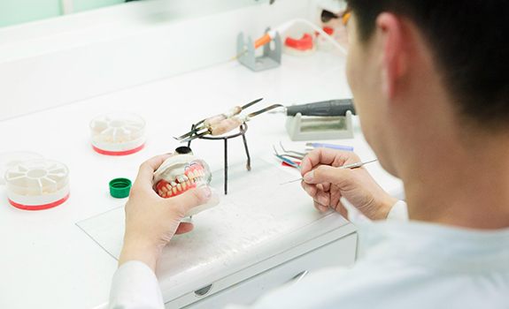 A lab worker crafting dentures