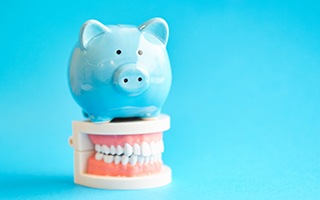 Piggy bank resting on a model of teeth