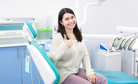 Female dental patient giving thumbs up after full mouth reconstruction in Rockwall, TX