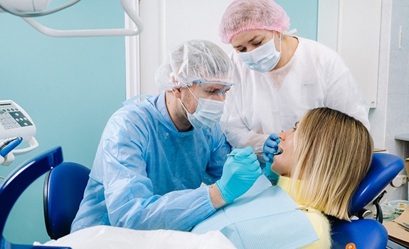 dentist looking at patient’s mouth 