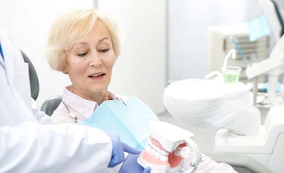 Implant dentist in Rockwall explaining procedure to an older patient