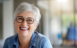 Senior woman with glasses sitting and smiling