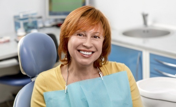 Smiling older woman at dental office for dental implant treatment