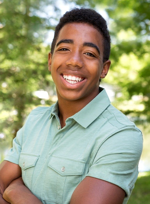 Young man with healthy aligned smile after orthodontic treatment