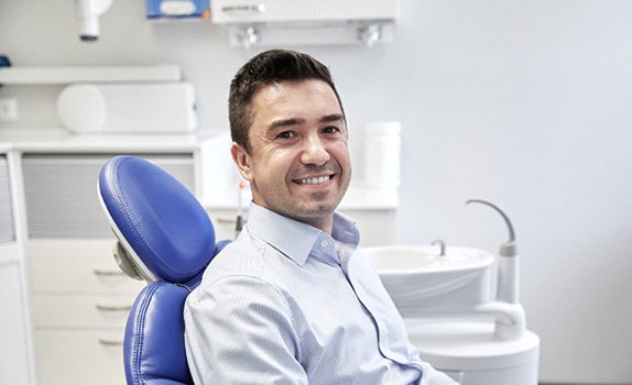 Man in dental chair smiling and waiting for treatment