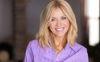 Woman in purple shirt smiling at home