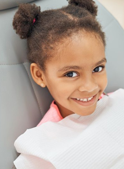 Happy young girl in dental treatment chair