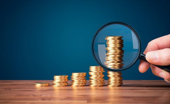 Stacks of coins examined with magnifying glass