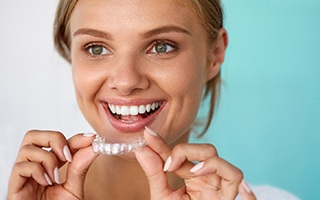 woman smiling while using whitening tray
