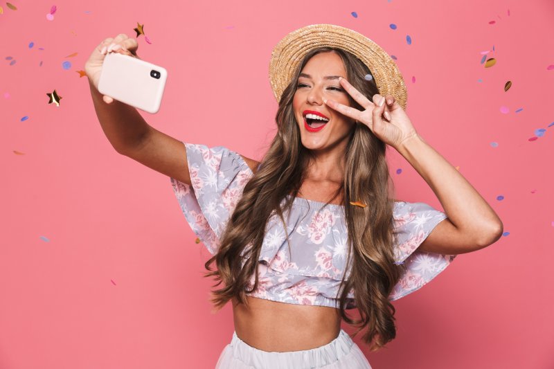 woman taking a selfie with dental implants in Rockwall