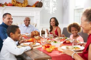 family sitting at table eating Thanksgiving dinner