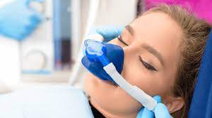person wearing nose mask administering nitrous oxide sedation