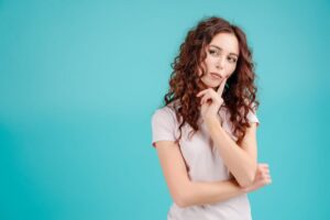 Young woman wearing curious, thoughtful expression 
