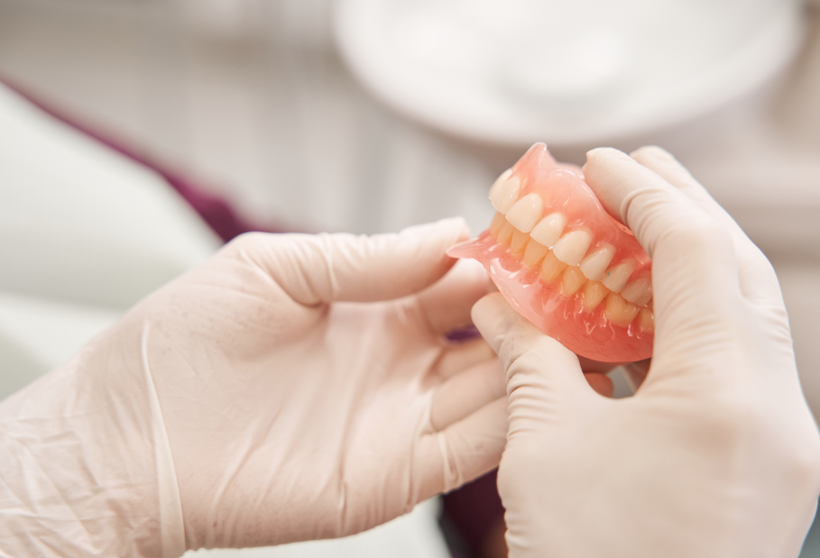 Dentist's hands holding denture
